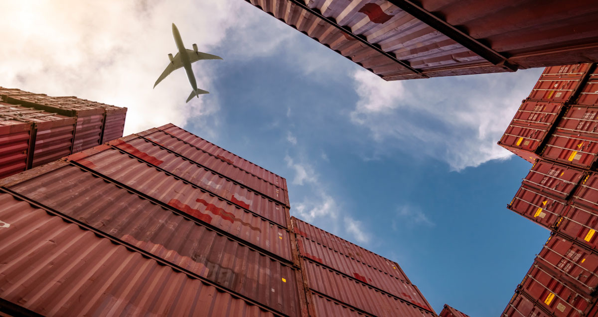 plane flying over cargo freight containers
